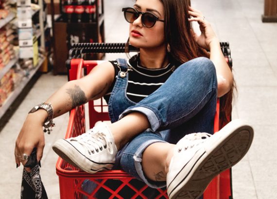 woman-wearing-blue-jeans-riding-red-shopping-cart-2321438